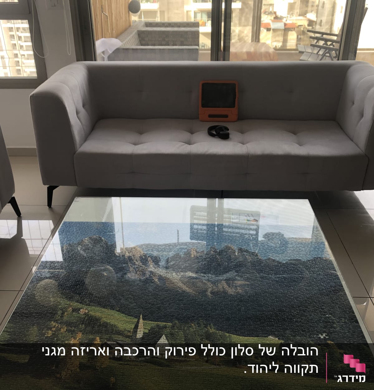 ספה אפורה עם טאבלט כתום ואוזניות שחורות